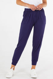 A model wearing the Paris Pant in colour Navy (Blue), from the front, cropped image