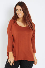 Model Laura wearing size 12 of the Milan 3/4 Sleeve Top in colour Terracotta (Red), from the front, cropped image