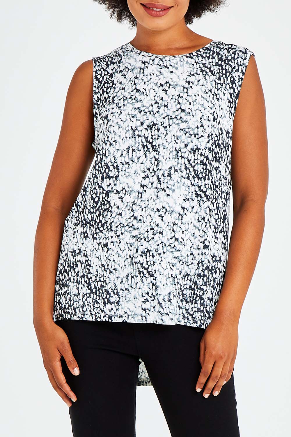 Model Olivia wearing size 10 of the Capri Tank in colour Spotty (White), from the front, cropped image