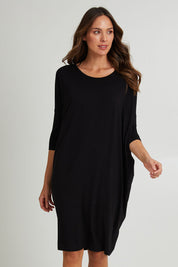 Model Madeline wearing size 10 of the Lucia Dress in colour Black (Black), from the front, cropped image