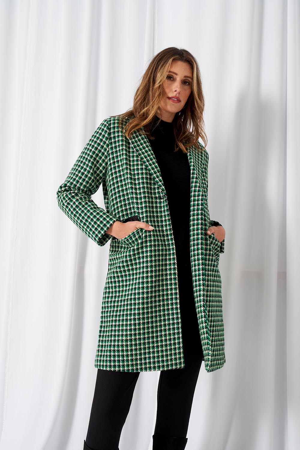 A model wearing the Wanda Coat in colour Greenhound (Green), from the front, showing the whole outfit