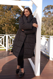 A model wearing the Shawl Puffer Jacket in colour Black (Black), from the front, showing the whole outfit