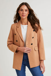 Model Madeline wearing size 10 of the Kaisley Blazer in colour Tan, from the front, cropped image