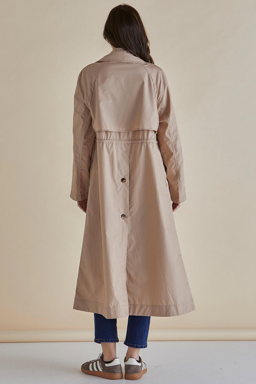 A model wearing the Parker Coat in colour Pebble, from the back