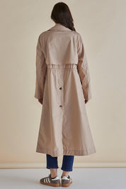A model wearing the Parker Coat in colour Pebble, from the back