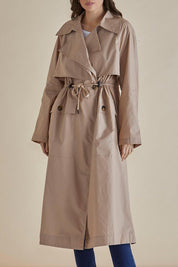 A model wearing the Parker Coat in colour Pebble, from the front, cropped image