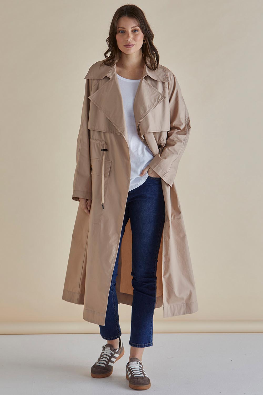 A model wearing the Parker Coat in colour Pebble, from the front, showing the whole outfit