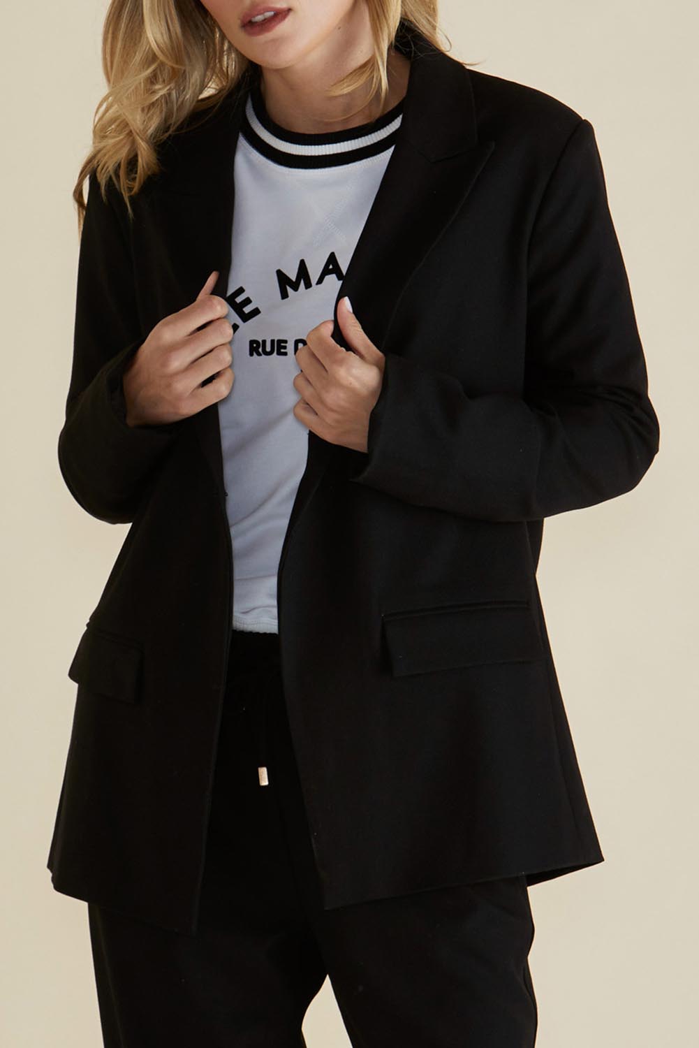 A model wearing the Portland Blazer in colour Black (Black), from the front, cropped image