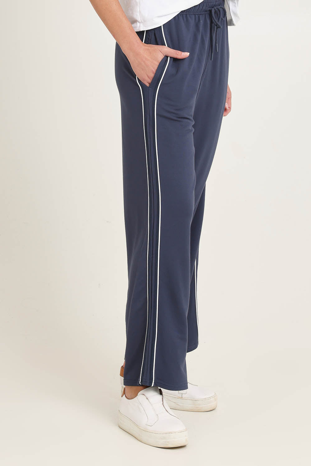Model Madeline wearing size 10 of the Evelyn Wide Leg Jogger in colour Petrol (Blue), from the front, cropped image