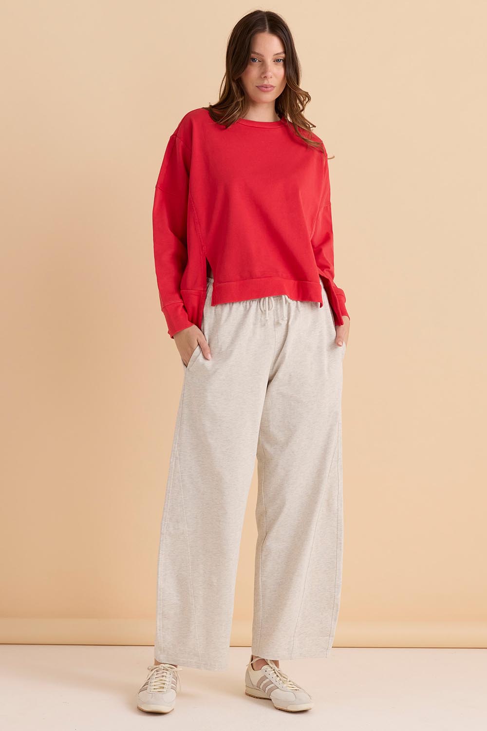 A model wearing the Iris Cotton Sweatshirt in colour Red (Red), from the front, showing the whole outfit