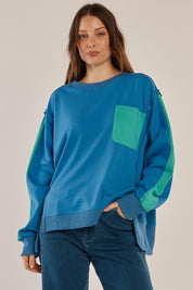 A model wearing the Tania Sweatshirt in colour Bluegreen (Blue), from the front, cropped image