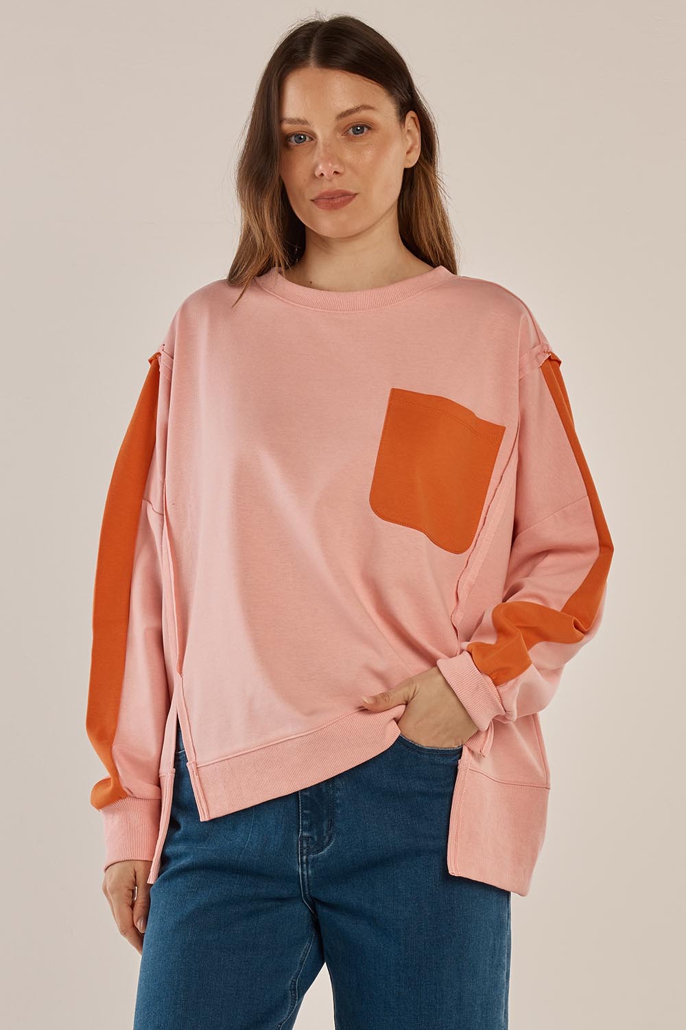 A model wearing the Tania Sweatshirt in colour Pinkorange (Pink), from the front, cropped image