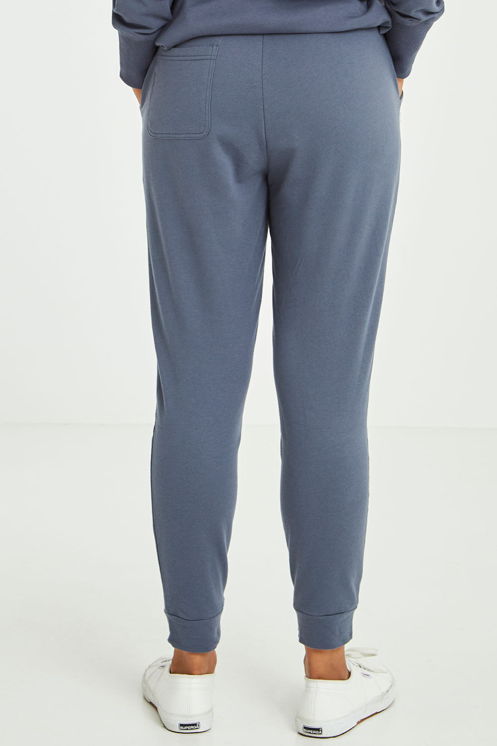 Model Olivia wearing size 10 of the Lindsay Jogger in colour Indiblue (Blue), from the back