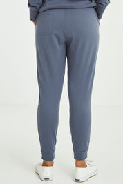 Model Olivia wearing size 10 of the Lindsay Jogger in colour Indiblue (Blue), from the back