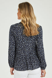 Model Alice wearing size 10 of the Lexton Blouse in colour Floral (Black), from the back