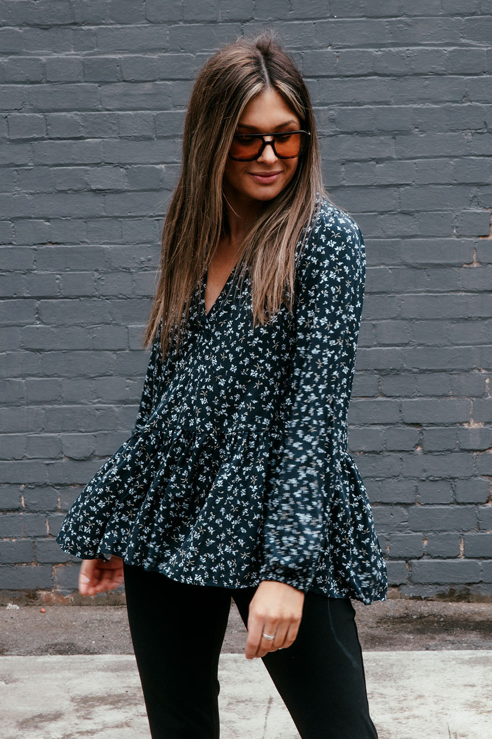 A model wearing the Lexton Blouse in colour Floral (Black), from the front, showing the whole outfit