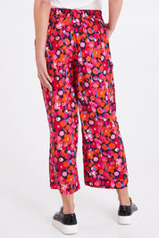Model Madeline wearing size 10 of the Sarah Pant in colour Brushflora (Pink), from the back