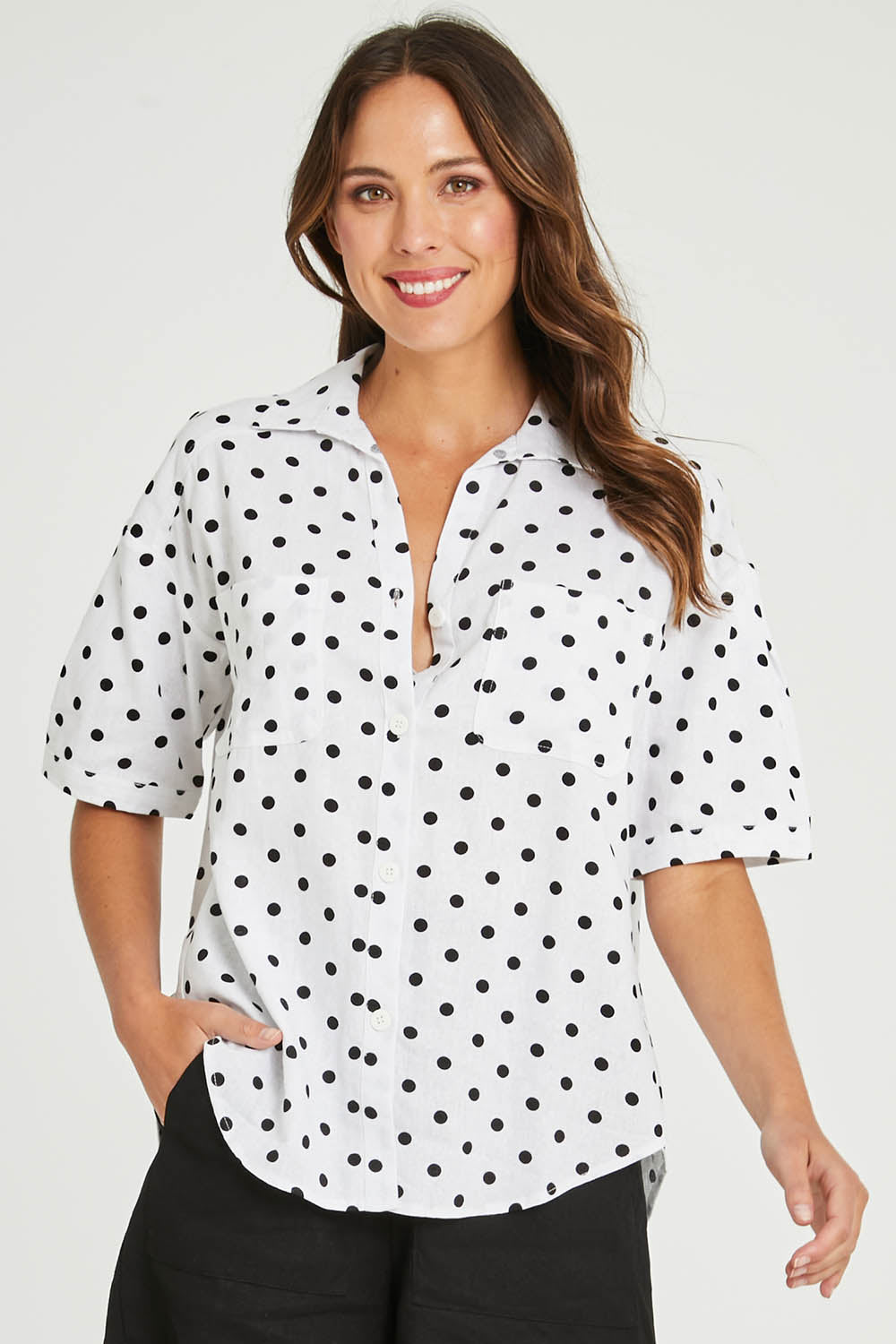Model Madeline wearing size 10 of the Catania Linen Shirt in colour Polkadot (White), from the front, cropped image