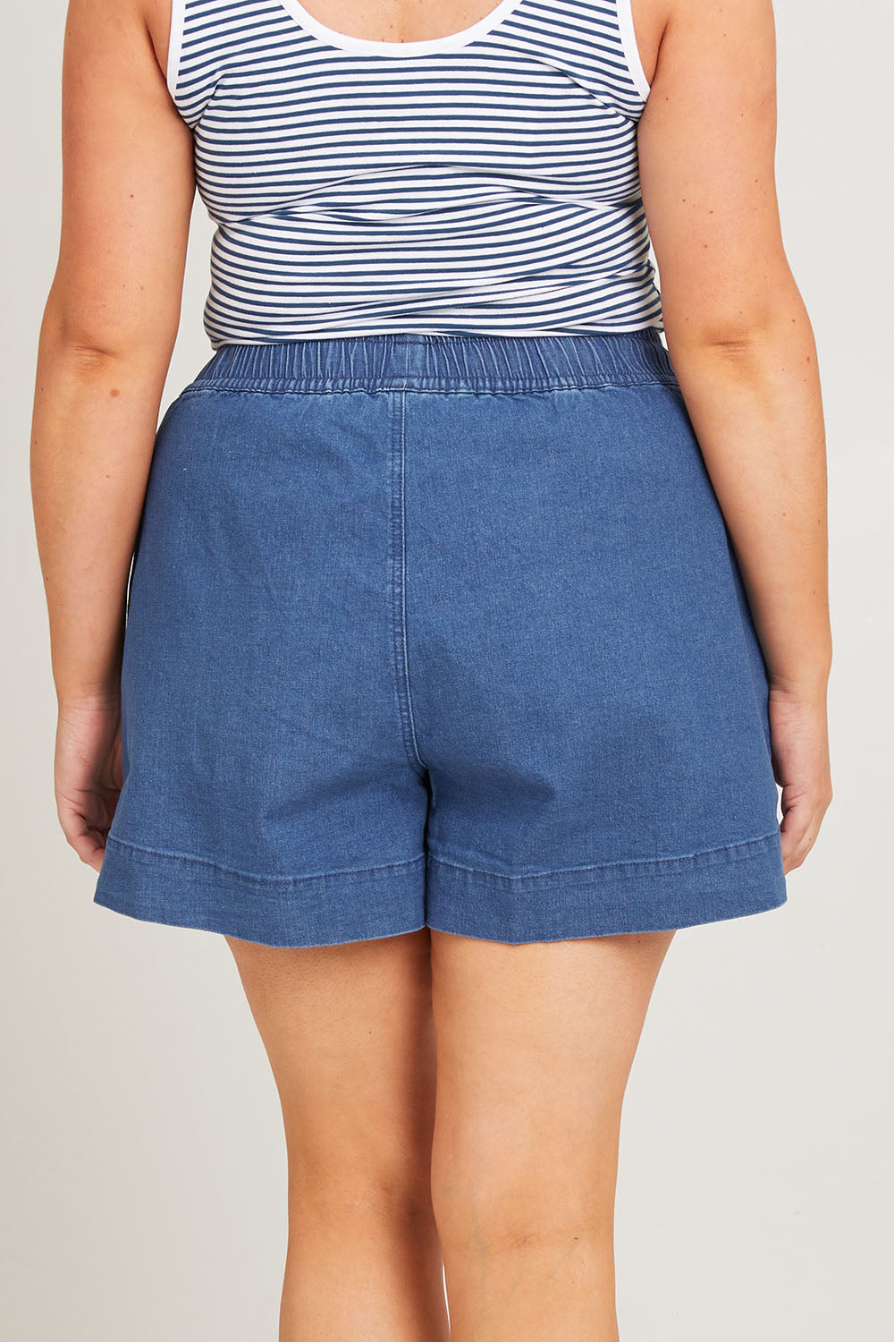 Model Poppy wearing size 16 of the Caroline Denim Short in colour Lightwash (Blue), from the back