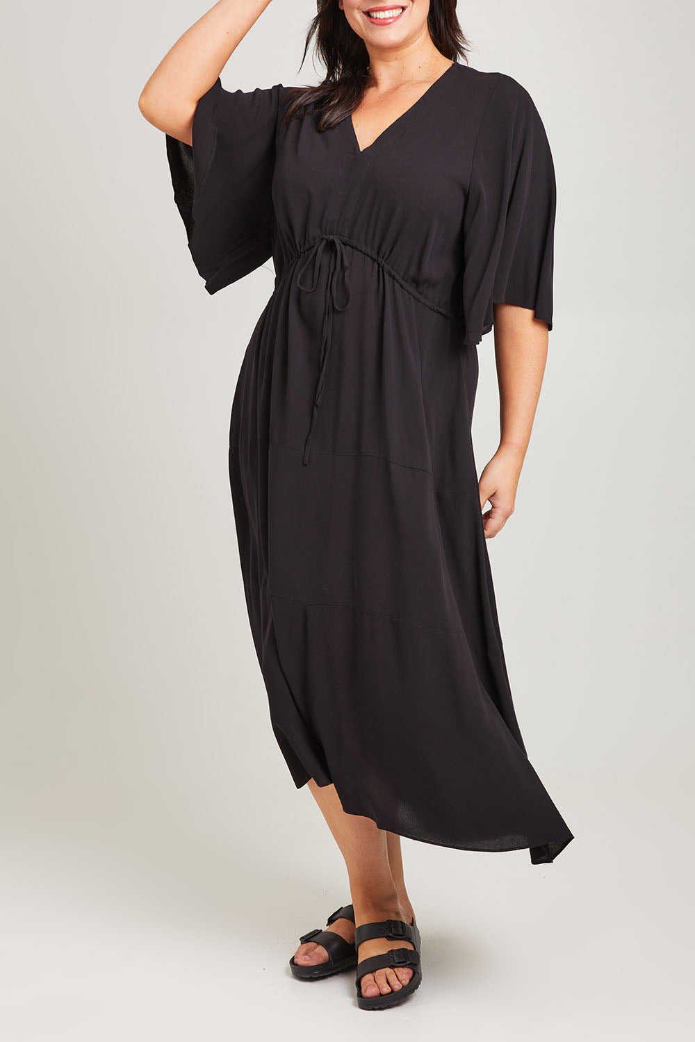 Model Poppy wearing size 16 of the Saint Lucia Dress in colour Black (Black), from the front, cropped image