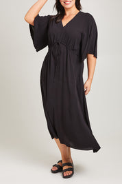 Model Poppy wearing size 16 of the Saint Lucia Dress in colour Black (Black), from the front, cropped image