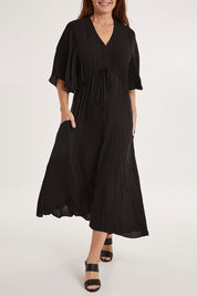 Model Sally wearing size 10 of the Saint Lucia Dress in colour Black (Black), from the front, cropped image