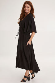 Model Sally wearing size 10 of the Saint Lucia Dress in colour Black (Black), from the front, showing the whole outfit
