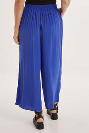 Model Sally wearing size 10 of the Olympia Pant in colour Decoblue (Blue), from the back