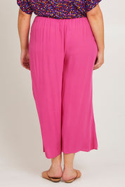 Model Poppy wearing size 16 of the Olympia Pant in colour Frenchrose (Pink), from the back