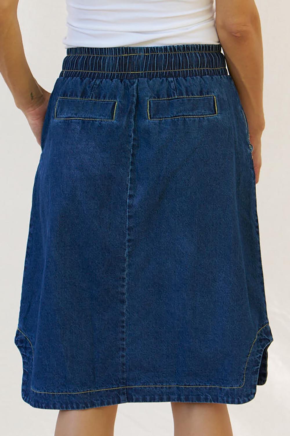 A model wearing the Desiree Cotton Denim Skirt in colour Bluewash (Blue), from the back