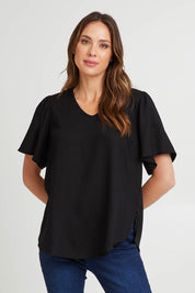 Model Madeline wearing size 10 of the Marina Linen Blouse in colour Black (Black), from the front, cropped image