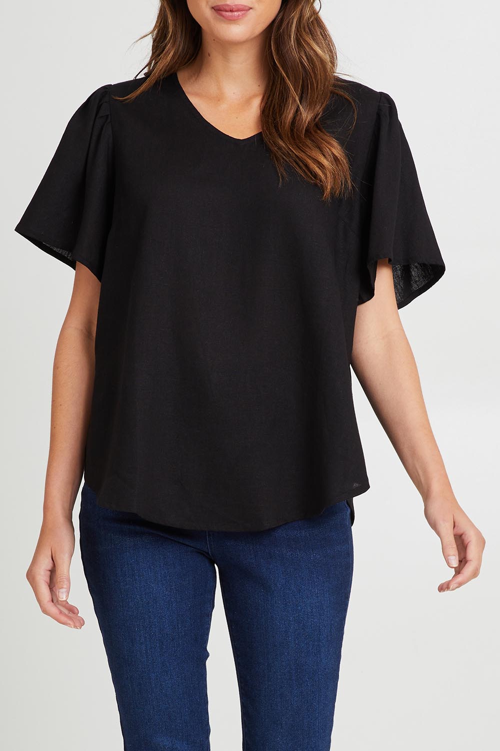 Model Madeline wearing size 10 of the Marina Linen Blouse in colour Black (Black), from the front, cropped image