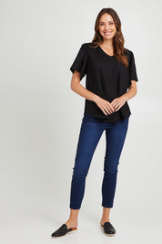 Model Madeline wearing size 10 of the Marina Linen Blouse in colour Black (Black), from the front, showing the whole outfit