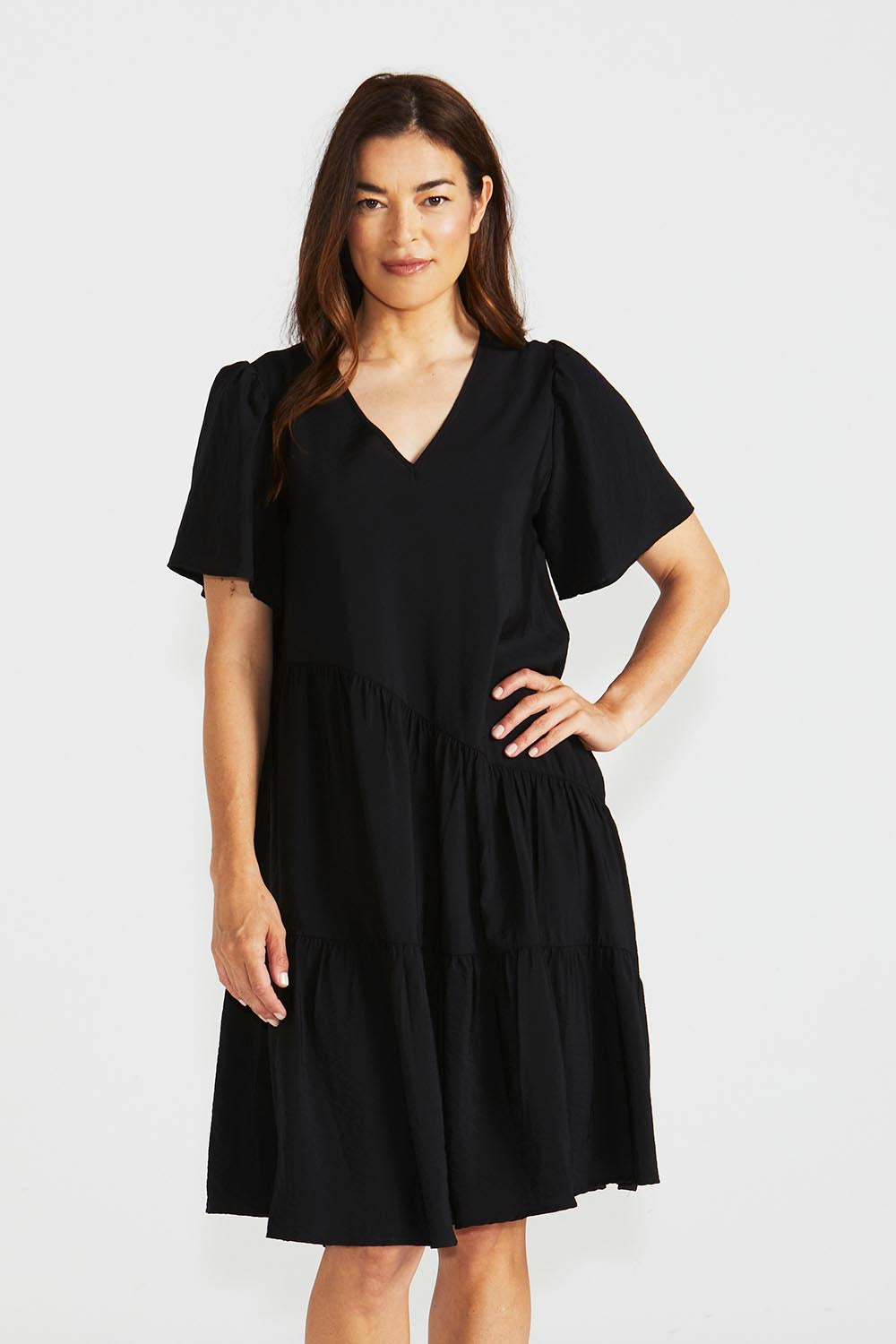 A model wearing the Florence Tiered Dress in colour Black (Black), from the front, cropped image