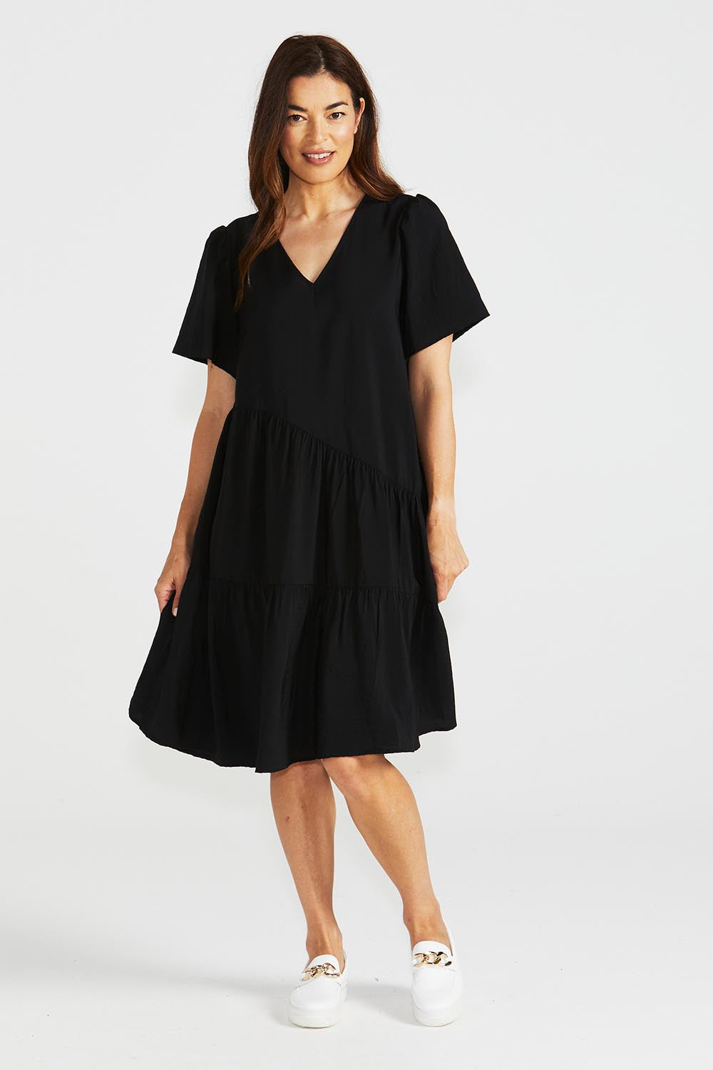 A model wearing the Florence Tiered Dress in colour Black (Black), from the front, showing the whole outfit