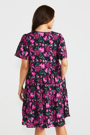 A model wearing the Florence Tiered Dress in colour Floral (Pink), from the back