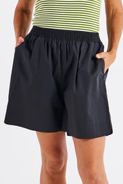 A model wearing the Pomona Cotton Short in colour Black (Black), from the front, cropped image