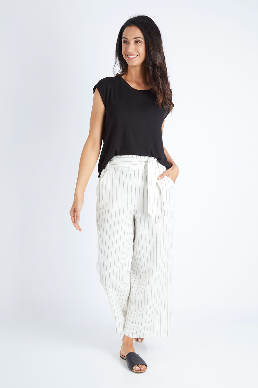 Model Gemma wearing size 10 of the Keto Pant in colour Pinstripe (White), from the front, showing the whole outfit