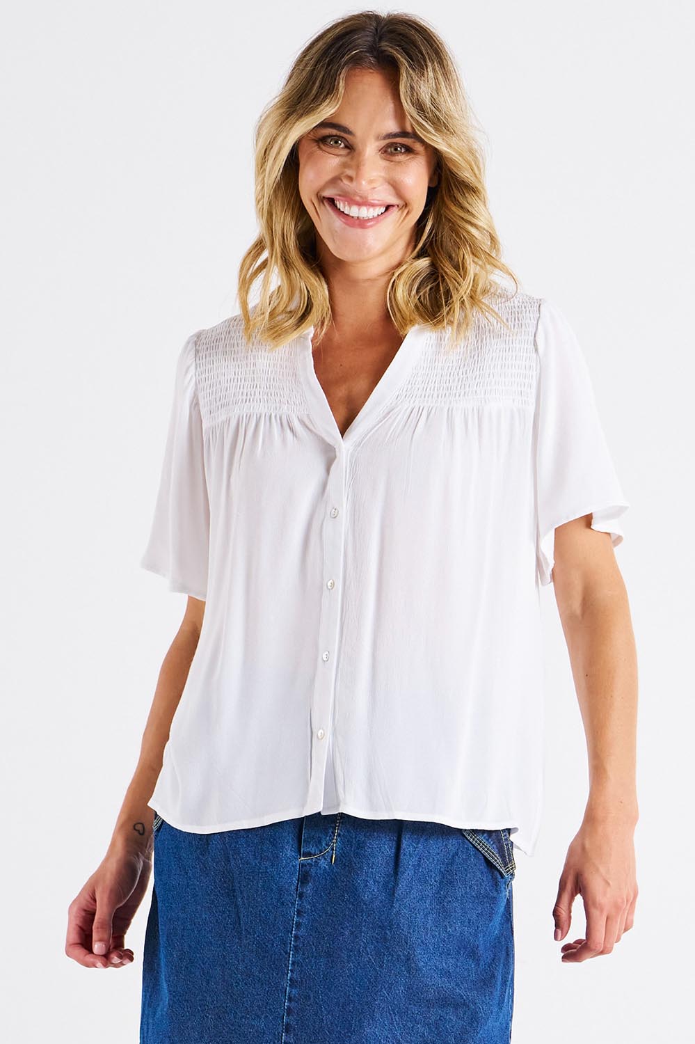 A model wearing the Sandy Shirred Blouse in colour White (White), from the front, cropped image