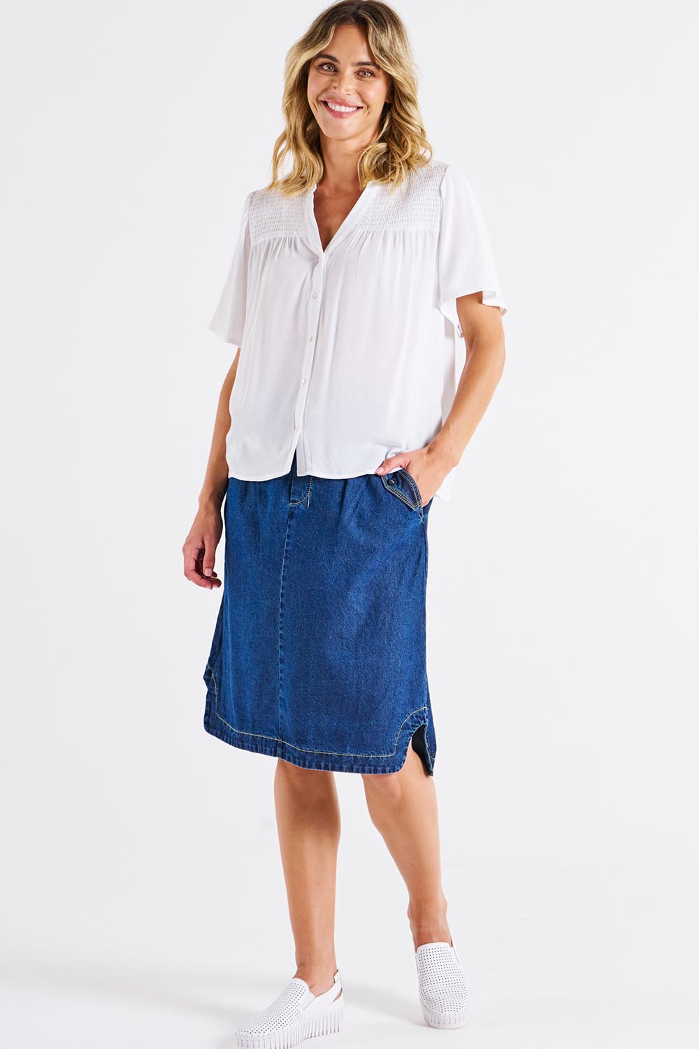 A model wearing the Sandy Shirred Blouse in colour White (White), from the front, showing the whole outfit