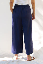 A model wearing the Aspen Linen Blend Palazzo Pant in colour Navy (Blue), from the back