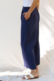 A model wearing the Aspen Linen Blend Palazzo Pant in colour Navy (Blue), from the front, cropped image