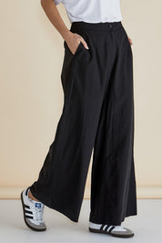 A model wearing the Wendy Wide Leg Cotton Pant in colour Black (Black), from the front, cropped image