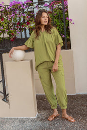A model wearing the Adrianna Jogger in colour Pistachio (Green), from the front, showing the whole outfit