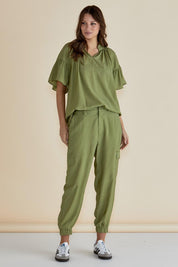 A model wearing the Adrianna Jogger in colour Pistachio (Green), from the front, showing the whole outfit