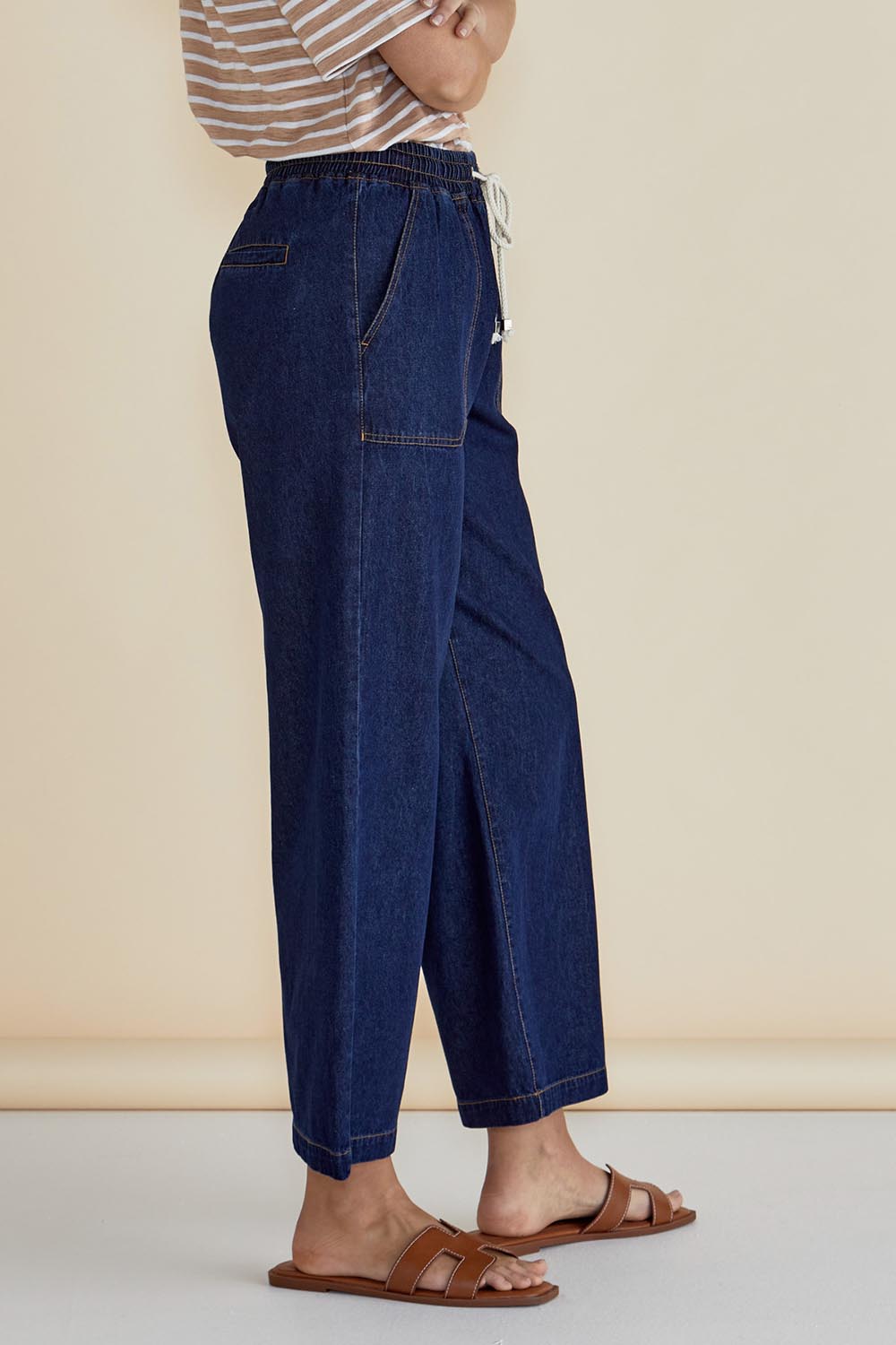 A model wearing the Drapey Denim Jogger in colour Sapphire (Blue), from the front, cropped image