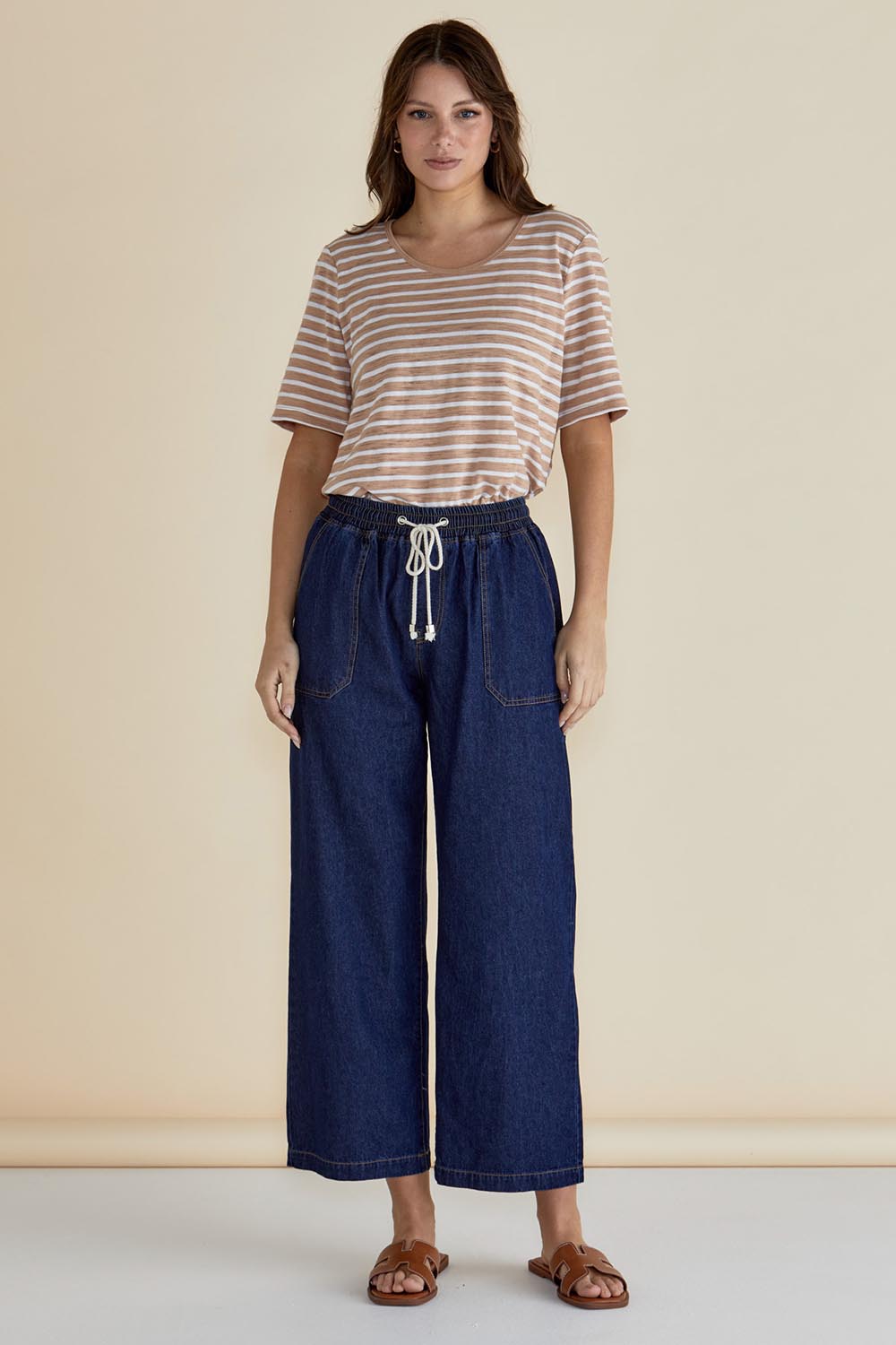 A model wearing the Drapey Denim Jogger in colour Sapphire (Blue), from the front, showing the whole outfit