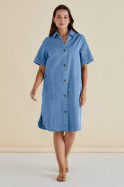 A model wearing the Dawson Denim Dress in colour Midwash (Blue), from the front, showing the whole outfit
