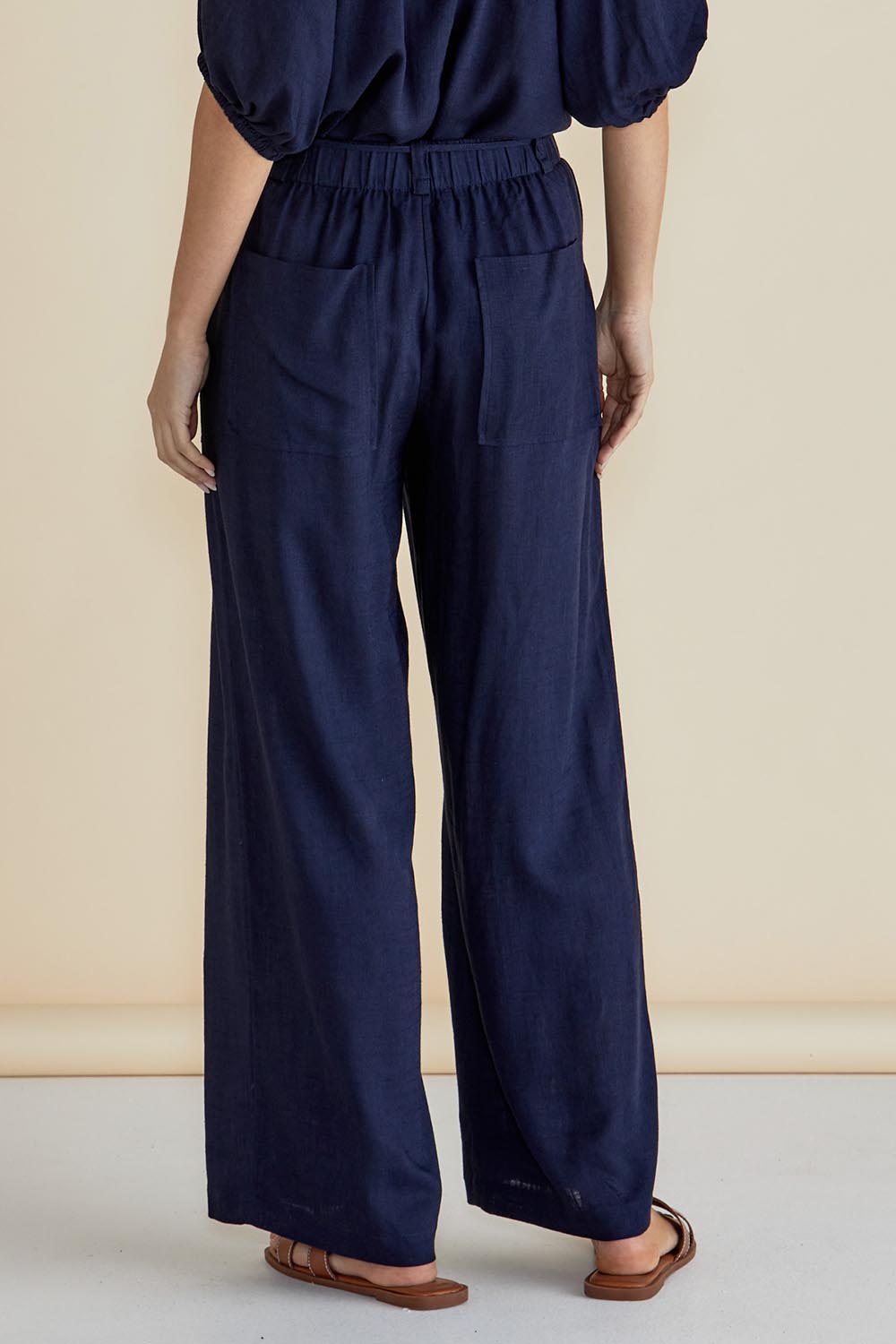 A model wearing the Tamara Pant in colour Darkblue (Blue), from the back
