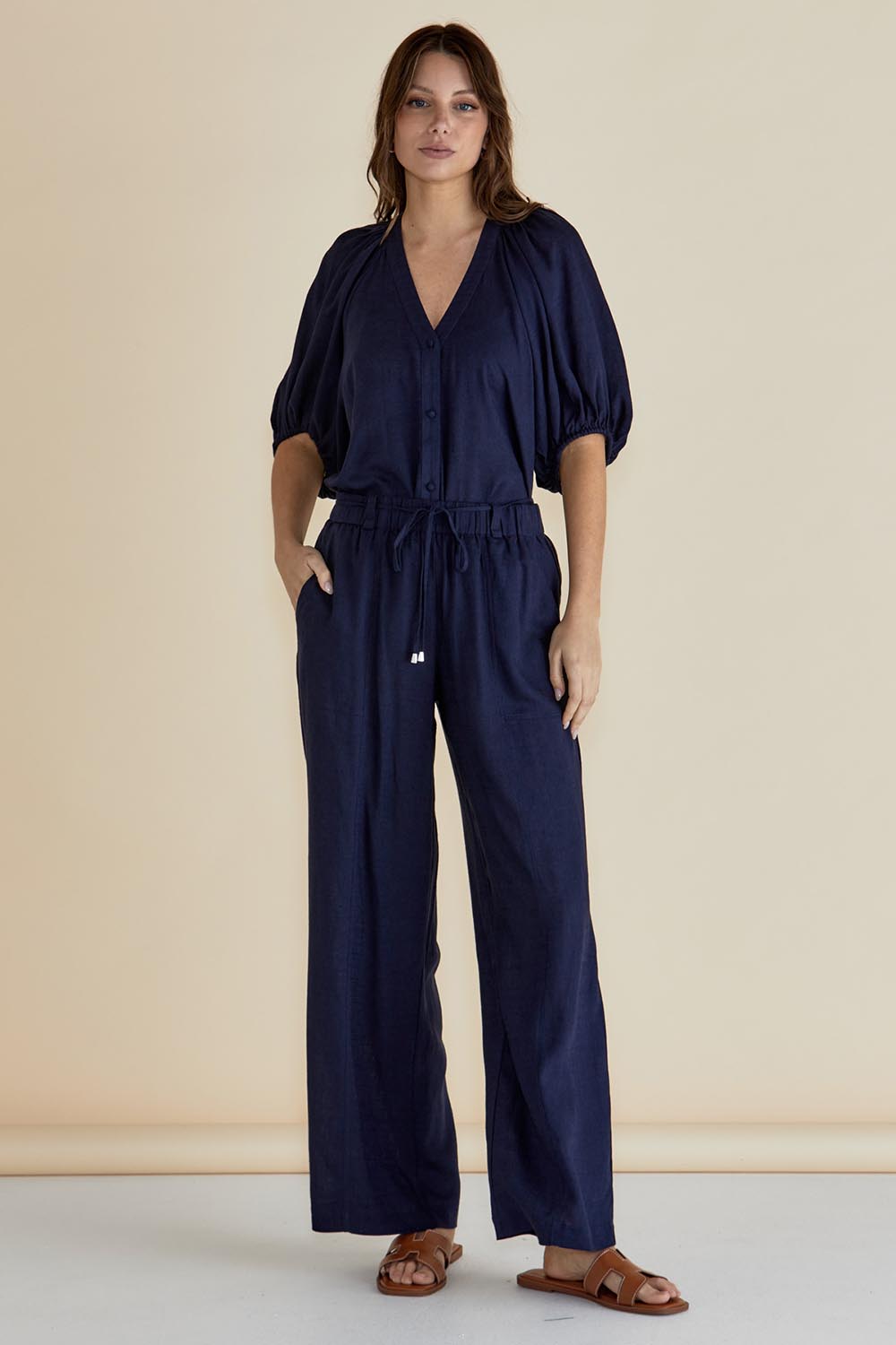 A model wearing the Tamara Pant in colour Darkblue (Blue), from the front, showing the whole outfit